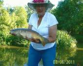 This is Janice Partridge with a nice mirror carp - proving that you don't necessarily need to wear camouflage to catch a fish!